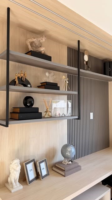 Estante com esculturas, livros pretos e objetos decorativos